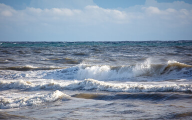 The ocean is very choppy and the waves are crashing