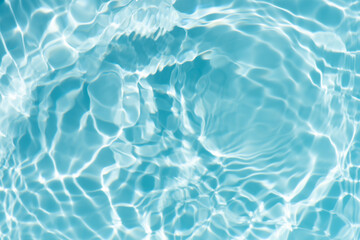 Blue water with ripples on the surface. Defocus blurred transparent blue colored clear calm water surface texture with splashes and bubbles. Water waves with shining pattern texture background.