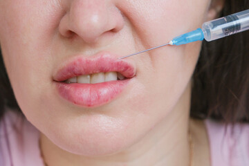 Obraz premium A woman gets hyaluronic acid injected into her lips. She's afraid to give injections.
