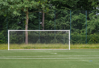 Blick auf einen Fußballplatz mit Kunstrasen während einer Trainingseinheit mit einem am Ende der Spielfläche - copy space
