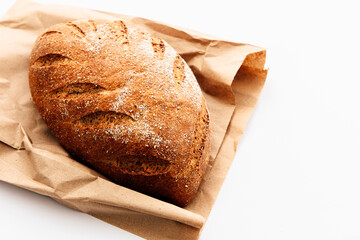 Freshly baked whole grain bread resting on brown paper
