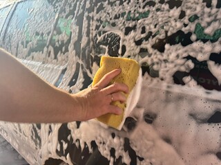 People cleaning car with sponge at car wash