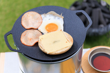 黒いマルチグリドルと具材のクローズアップ、芝生の緑を背景に