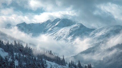 Snow covered mountain peaks shrouded in mist and clouds with pine forest foreground mountains winter