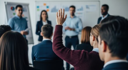 Engaged participant raises hand to ask a question during an interactive corporate training session with diverse speakers