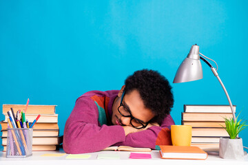 Young student resting surrounded by study materials and colorful decor over a blue background