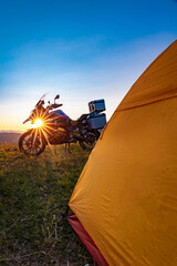 Camping with a motorcycle with a yellow tent in the mountains.