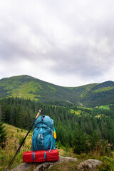 Summer hiking in the mountains with a backpack and a tent. Beautiful mountain landscape.