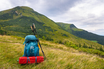 Summer hiking in the mountains with a backpack and a tent. Beautiful mountain landscape.