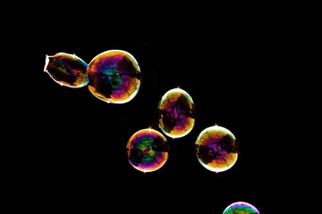 Cluster of Colorful Soap Bubbles with Gold, Pink, and Rainbow Iridescence on Black Background - Abstract Bubble Photography Showing Multiple Spheres with Light Reflections and Artistic Composition

