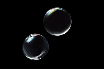 Two Large Transparent Crystal Clear Bubbles on Black Background - Macro Close-up Photography Showing Perfect Spheres with Glass-Like Appearance, Reflections, and Ethereal Clarity

