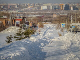 One of the city streets. Snow covered sidewalk. Grunge cityscape. City view. After the snowfall in Ust-Kamenogorsk (kazakhstan)