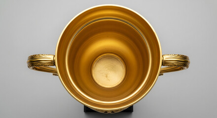 Golden Two-Handled Trophy Cup Top-Down View on Grey Background