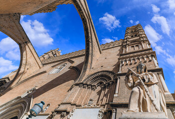 West facade of Palermo Cathedral, southern Italy. View of the ogival arches and bell tower: view from below of the 18th-century sculpture of Saint Francis of Paola and the splayed opening monofora.