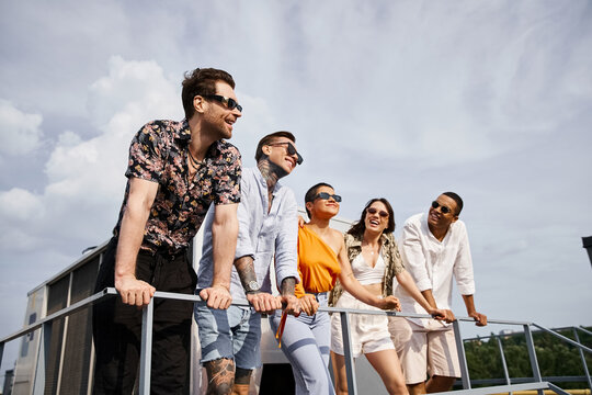 Friends celebrate friendship with laughter and joy at a rooftop gathering in sunny weather