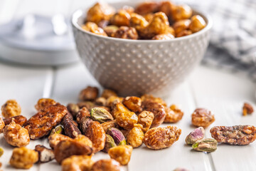 Nuts coated in sugar glaze on white table.
