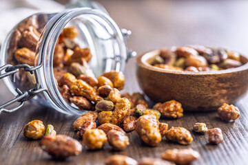 Nuts coated in sugar glaze on wooden table.