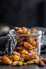 Nuts coated in sugar glaze on black table.