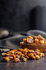 Nuts coated in sugar glaze on black table.