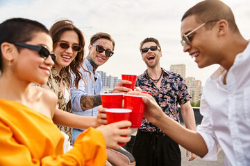 Friends celebrate happiness together on a vibrant rooftop party during a sunny afternoon