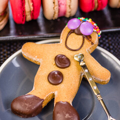 A gingerbread man with chocolate buttons has a fancy spoon representing his heart