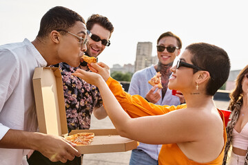 Friends celebrate friendship and enjoy pizza together on a sunny rooftop party