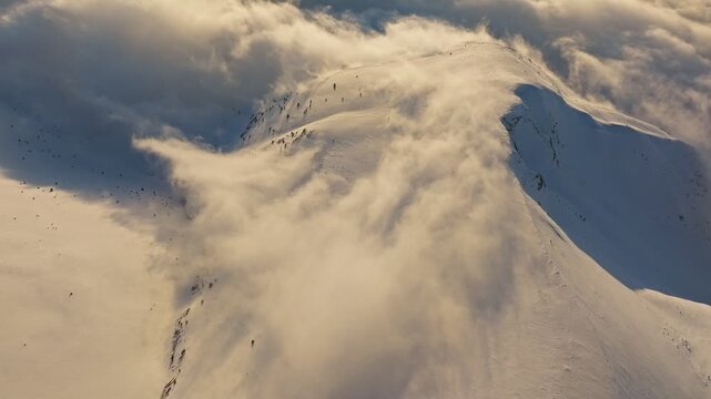 Snow cascading swiftly, Powdery snow swirls dynamically, Snowflakes tumble down steep mountain slope, Airborne snow creates swirling cloud with textured shadows and motion