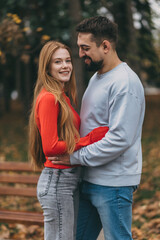 Fototapeta premium joyful autumn companionship, smiling pair enjoying fall weather, happy couple relaxing amidst autumn scenery