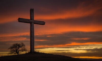 A weathered wooden cross atop a hill against a vibrant sunset sky