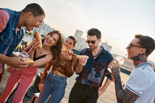 Young friends celebrate a joyful gathering on the rooftop with delicious snacks and laughter