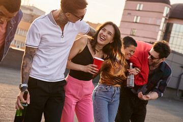 Young friends celebrate together on a rooftop under the evening sky
