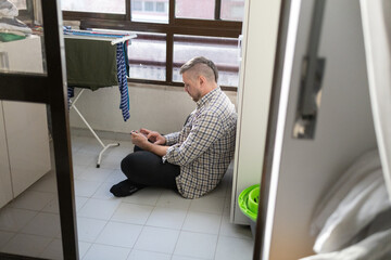 Man sitting on floor using smartphone feeling relaxed