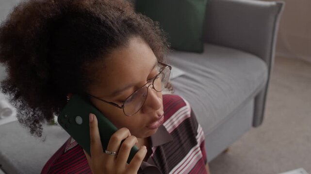 Stressed woman at home surrounded by overdue bills, arguing on phone while managing finances, showing worry, frustration, and emotional burden of unpaid expenses