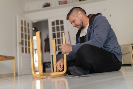 Man assembling wooden furniture, home improvement diy project