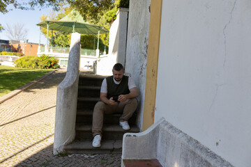 Man sitting on stairs using mobile phone browsing internet