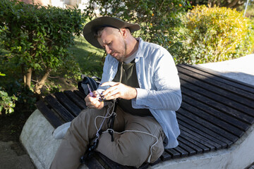 Man untangling climbing gear on a park bench