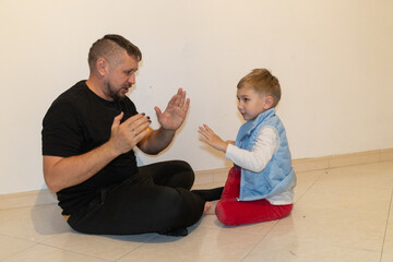 Father and son playing together clapping game