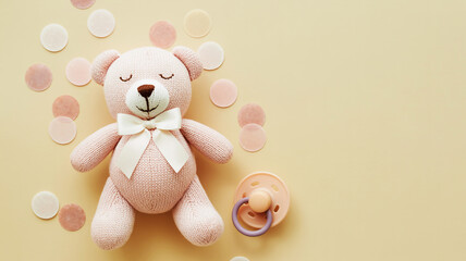 Cute pink teddy bear with pacifier and confetti on a soft yellow background