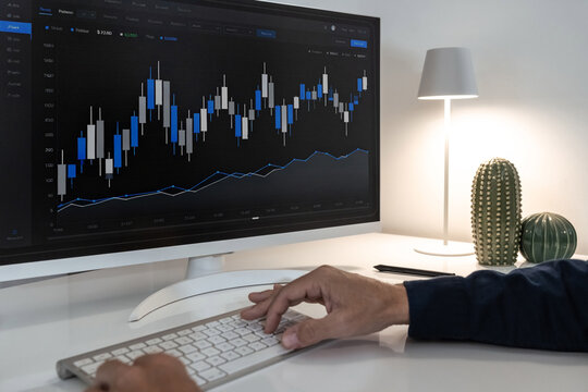 Trader or Analyst Monitoring Live Financial Candlestick Charts on a Desktop Monitor to Execute a Market Strategy - Powered by Adobe