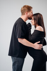 Expecting parents share a tender moment in a studio