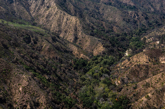 Aerial view of dry mountain ridges and winding dirt trails in Southern California showing rugged terrain, sparse vegetation, and dramatic natural landforms