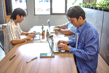 Team Collaborating On Laptops In Modern Co Working Space
