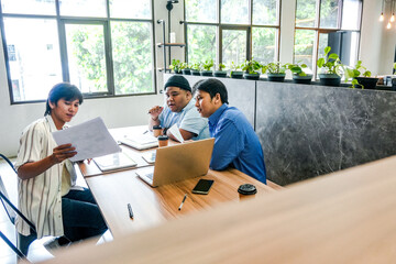 Young Professionals Collaborate Discussing Project Strategy In Office Space