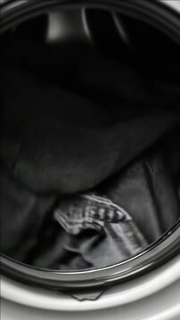 Denim jeans spinning inside a top-loading washing machine.
