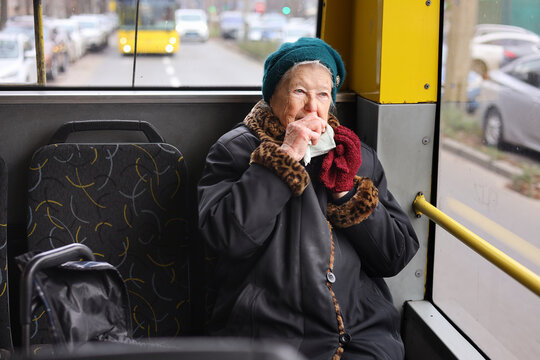 A senior woman is sitting on a bus, using her smartphone. She is traveling through the city, enjoying her journey in a relaxed manner. - Powered by Adobe