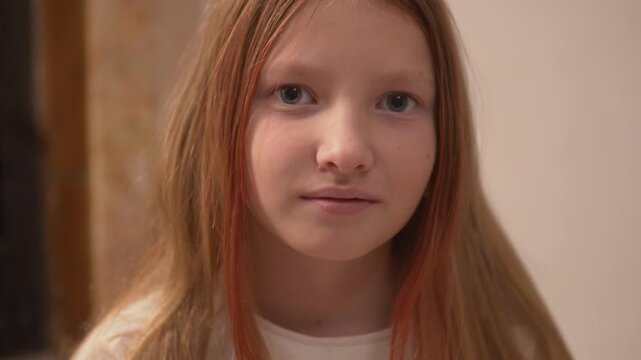 Happy Beautiful little girl with a mole under her nose smiling at the camera and looking with cunning eyes