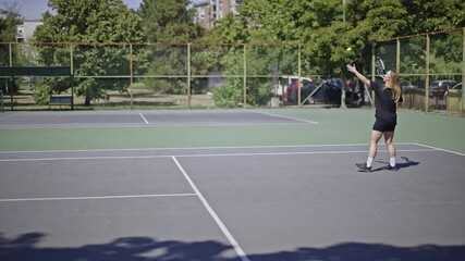 Joyful friends engage in a lively game of tennis on a sunny outdoor court. This vibrant footage captures their active lifestyle, showcasing fitness, healthy activity and fun on a beautiful summer day.