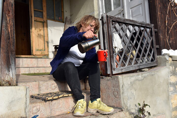 Woman pours coffee from coffee percolator in can