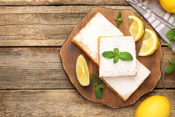 Tasty lemon bars with mint and fresh fruits on wooden table, flat lay. Space for text
