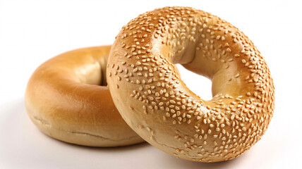 Two bagels on a white surface, one covered in sesame seeds, delicious breakfast food item close up